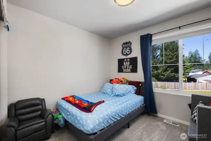 Bedroom with carpet flooring, a large window, and space for a variety of furniture arrangements.