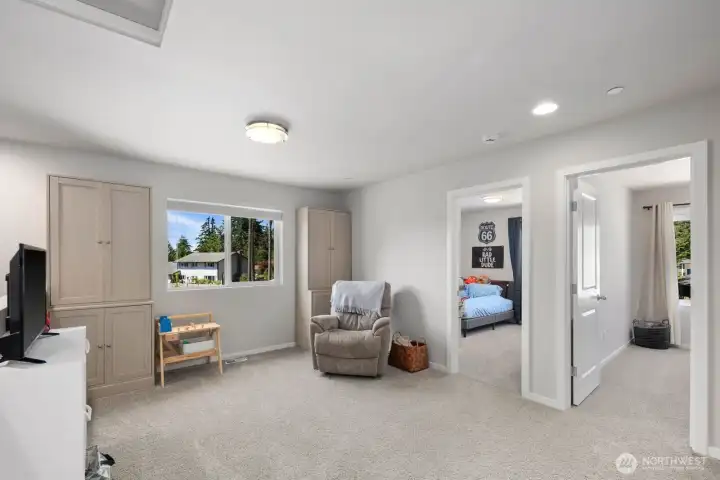 Flexible living space with carpet flooring, natural light, and room for a variety of uses.