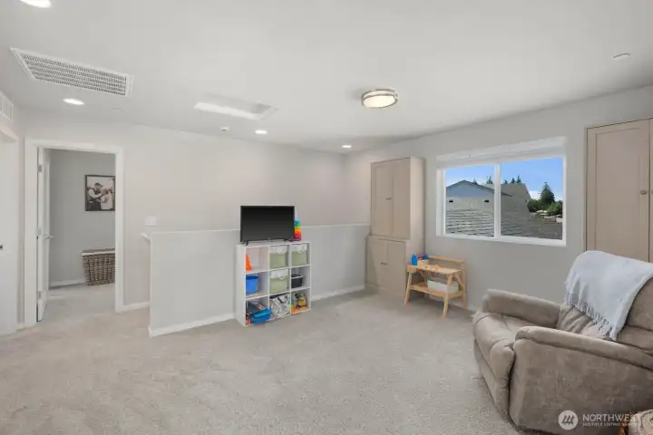 Additional living space with carpet flooring, natural light, and an open layout.