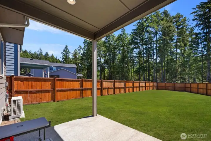 Covered outdoor living area overlooking the fully fenced backyard.