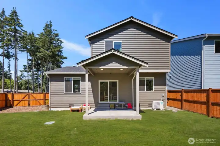 Expansive backyard featuring a large lawn area, perimeter fencing, and mature trees beyond the property line.