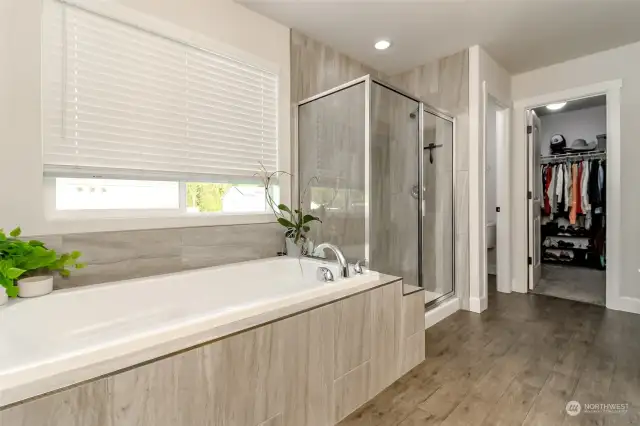 A soaking tub that is long enough to stretch out in and step in shower are hi-lites of this beautiful primary suite bathroom.