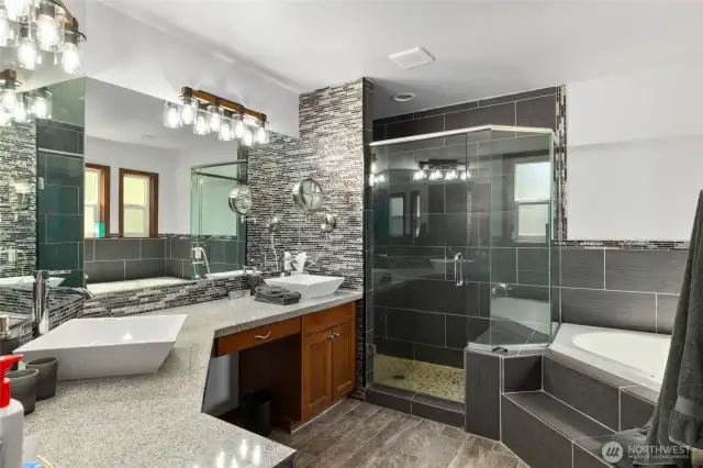 Primary Suite bath features double sinks, granite counters, a corner soaking tub, & gorgeous large tiled shower.