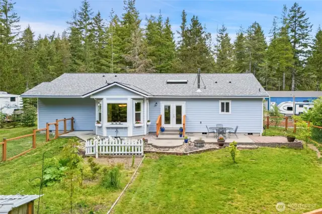 Fenced in back yard with patio and multiple garden areas.