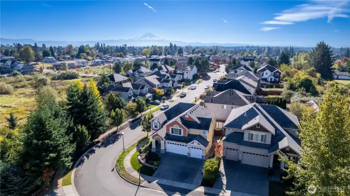 Take in the stunning aerial view of this peaceful East Hill neighborhood in Kent. From above, you can see the quiet, tree-lined streets, Mount Rainier in the distance, and well-kept homes that make this community so desirable. This corner-lot home enjoys the feeling of a cul-de-sac with minimal traffic—perfect for peaceful living close to parks, schools, and local conveniences.