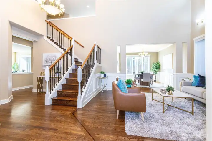 The grand staircase immediately draws your eye as you enter the main living area. Soaring ceilings, elegant light fixtures, and hardwood floors give the space warmth and style. The open layout connects seamlessly to the dining room, making this the perfect area for entertaining or relaxing at the end of the day.