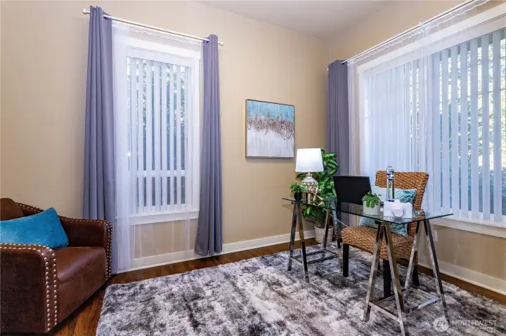 The office sits just off the main entry—ideal for working from home or creating a quiet reading nook. Large windows with vertical blinds allow for privacy while letting in soft, natural light. The room’s neutral tones and hardwood floors make it easy to customize for any need—whether it’s a productive workspace or a cozy retreat.