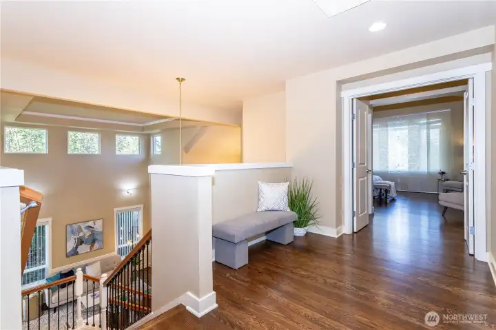 From the top of the stairs, enjoy the home’s open design with multiple windows bringing in tree-filtered light. The upper hallway connects to all bedrooms and the loft, while overlooking the dramatic two-story living room below—an elegant architectural focal point that ties the home together beautifully.