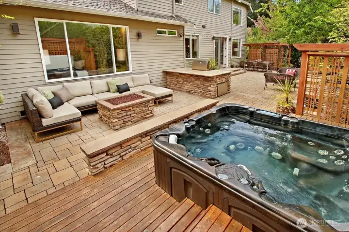 Enjoy a dip in the hot tub with custom decking, custom lighted bench and charming privacy wall!