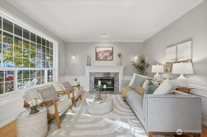 Formal Living Room (one of 3 living room spaces).  This home lives so large!  In this living space, enjoy natural gas fireplace, hardwoods, wainscoting, crown molding, LARGE front window overlooking the beautiful, professional landscape!  All windows & screens recently replaced.