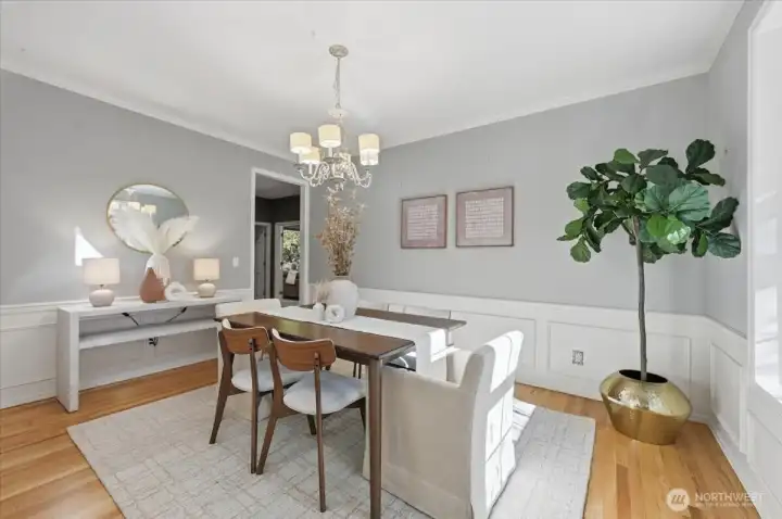 Formal dining room offers crown molding, hardwoods, wainscoting & a beautiful view to the covered front porch and beautiful, professional landscape!