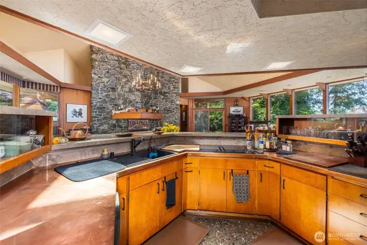 Custom, newly polished copper countertops pair beautifully with a bespoke tiled backsplash designed to complement the home’s signature stonework. Custom, newly polished copper countertops pair beautifully with a bespoke tiled backsplash designed to complement the home’s signature stonework.
