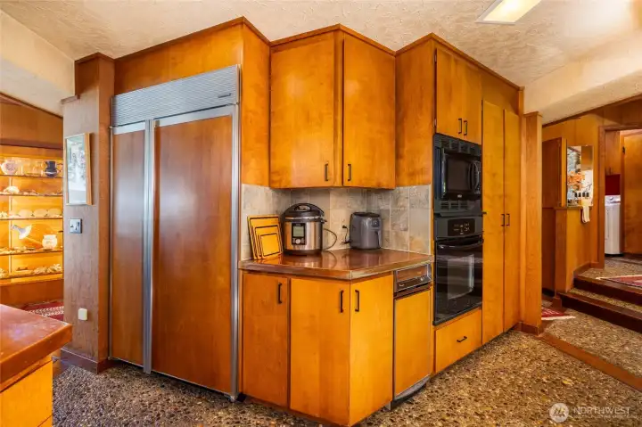 A chef’s layout featuring a walk-in pantry, high-end integrated refrigeration hidden behind matching wood veneers, and premium flush-mount cooktops. A chef’s layout featuring a walk-in pantry, high-end integrated refrigeration hidden behind matching wood veneers, and premium flush-mount cooktops.