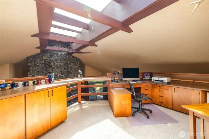 A striking architectural feature, this workspace cantilevers dramatically over the main living area, offering views of the massive rock fireplace. Includes dual built-in desk workstations and extensive custom cabinetry. A striking architectural feature, this workspace cantilevers dramatically over the main living area, offering views of the massive rock fireplace. Includes dual built-in desk workstations and extensive custom cabinetry.