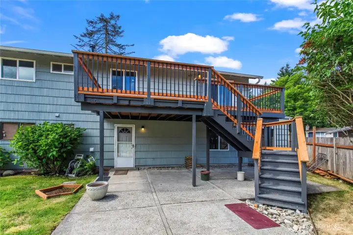 Beautiful patio and balcony overlooking a fully fenced spacious back yard with peekaboo views of the sound