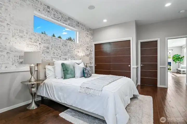Main floor bedroom features wallpaper by Dan Funderburgh, and connects to the main floor bathroom through the closed door on the right. Main floor bedroom features wallpaper by Dan Funderburgh, and connects to the main floor bathroom through the closed door on the right.