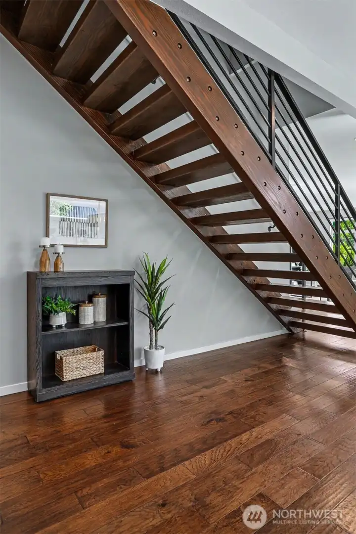 Closeup of the wood & steel floating staircase that leads up to the other 3 bedrooms, including the Primary Bedroom. Closeup of the wood & steel floating staircase that leads up to the other 3 bedrooms, including the Primary Bedroom.