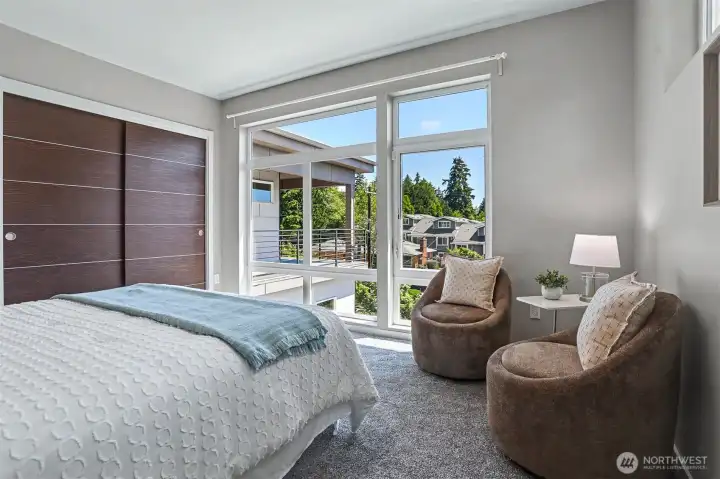 The large floor-to-ceiling windows in this upstairs guest bedroom face south. The large floor-to-ceiling windows in this upstairs guest bedroom face south.