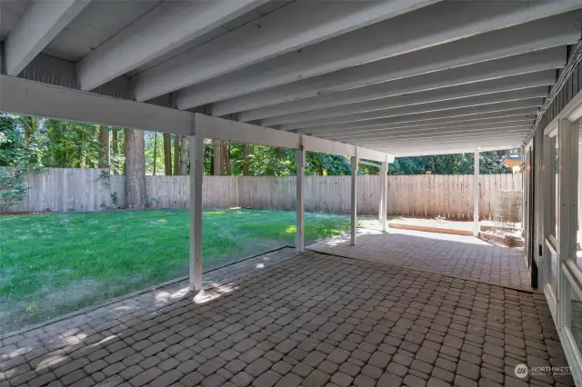 Huge private back yard showing deck above and patio.