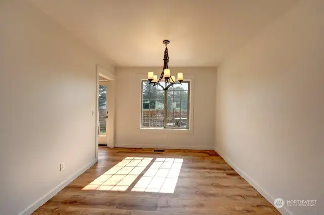 The formal dining room overlooks the fenced back yard and patio.