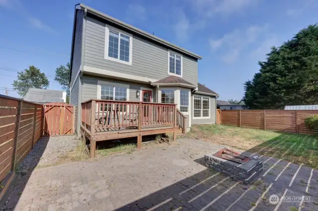 The fenced back yard is set up for entertaining and fur babies. Complete with fire pit, concrete patio and raised deck.