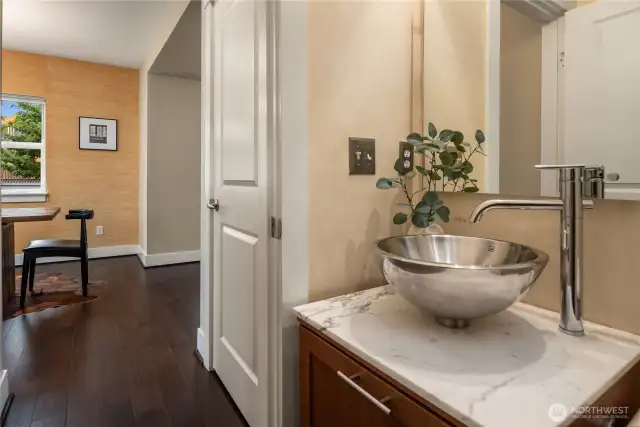 Just down the hall from the living and dining room is this stylish powder room complete with vessel sink and marble top.