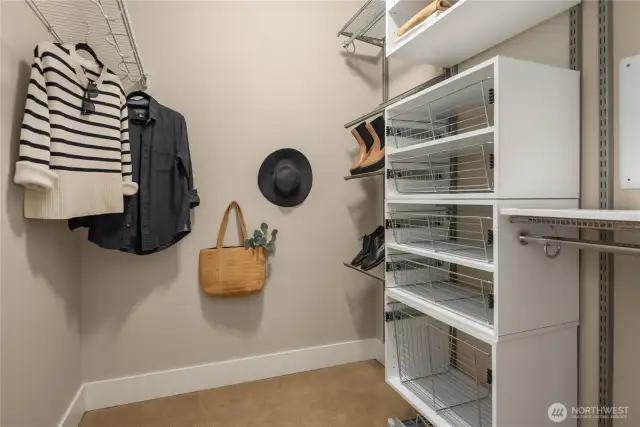 Walk-in closet with built in systems is a welcome luxury.
