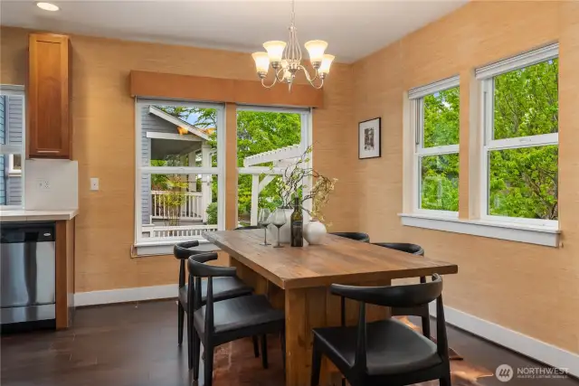 This spacious dining room features great light through four separate windows and a soft grass wallpaper finish.