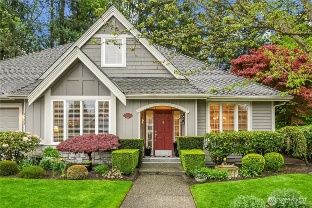 Storybook streetside exterior with English Castle Stone wainscotting, Traditional lap siding, and wood shingle accenting.