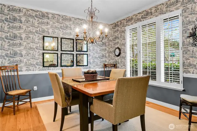 Formal dining room. 9-foot ceiling with crown moulding. Ornate Antique-style chandelier on adjustable dimmer. Divided-light windows with two-inch Plantation-style shutters. Formal, painted chair-rail wainscoting with Traditional-style wallpaper. Recessed dining hutch alcove. Oak-hardwood floor. William Buchan signature detail moldings.