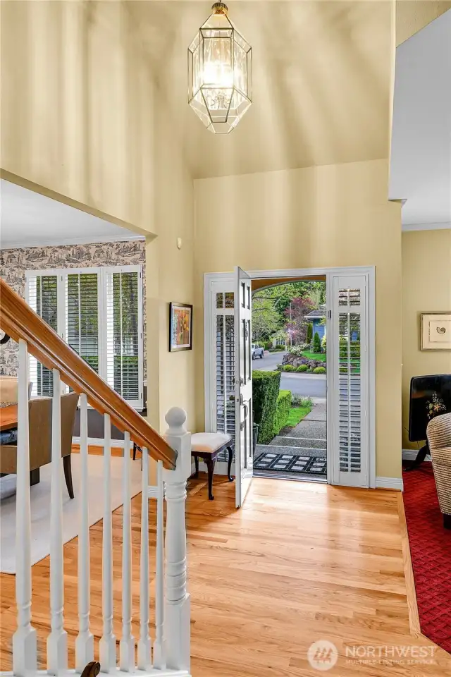 Entry interior. Dramatic, soaring ceiling with Traditional-style polished-brass-beveled-glass entry chandelier. Beautiful oak-hardwood floor. Elegant, atypical staircase with Traditional balustrade, oak-hardwood treads, formal painted risers.