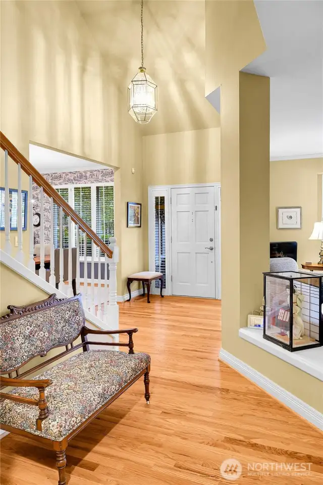 Entry interior. Dramatic, soaring ceiling with Traditional-style polished-brass-beveled-glass entry chandelier. Beautiful oak-hardwood floor. Elegant, atypical staircase with Traditional balustrade, oak-hardwood treads, formal painted risers.