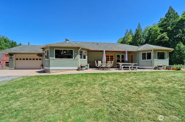 Front of house and front patio area with doors to kitchen, office and primary bedroom.