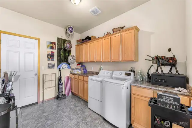 A very large laundry room with an abundance of storage.