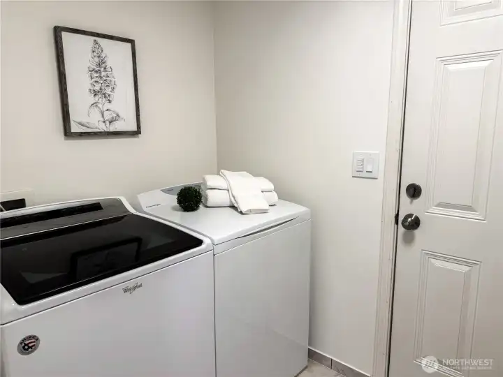 Convenient main-floor laundry room with full-size washer and dryer, sink (not in picture), and access to the garage.