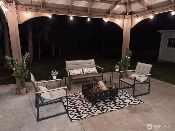 Your outdoor living space transforms at night with beautiful string lighting, creating an enchanting atmosphere for year-round enjoyment.