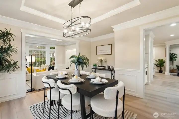 Alternate dining perspective showcasing wainscoting and open flow to adjacent rooms.