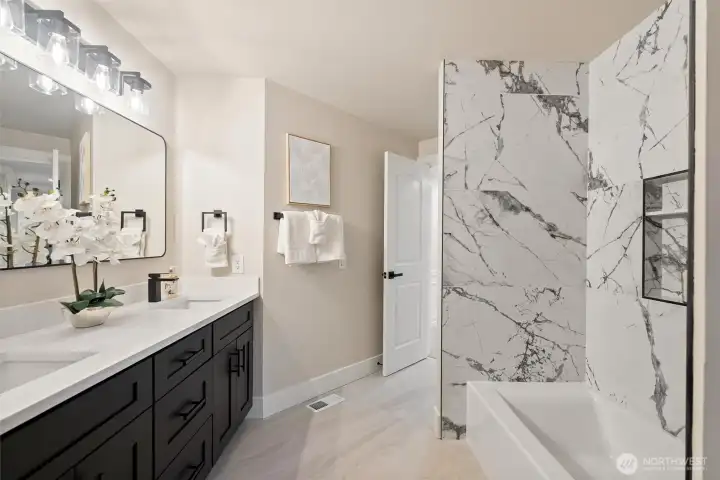 Updated bathroom featuring dual vanity and contemporary finishes.