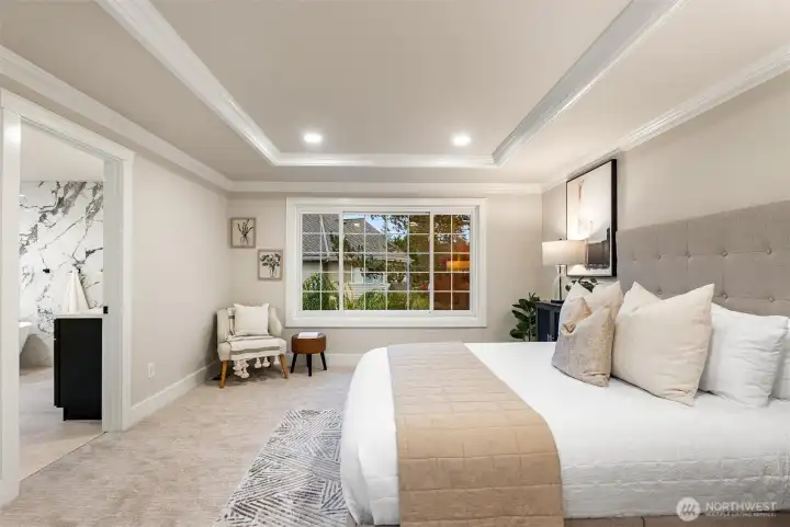 Primary bedroom with sitting area and generous natural light.