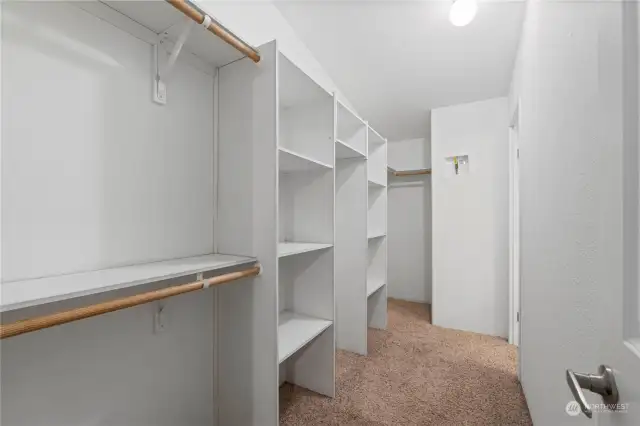 Primary suite offers lots of storage in this walk-in closet that connects to the bathroom.