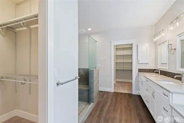 Large primary bath with large walk-in shower, 2 closets, 2 sinks, a make-up counter and so much storage.