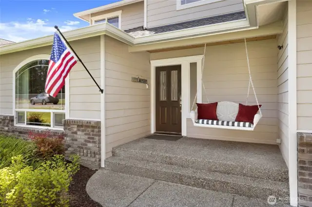 Spacious front patio w/swing bench welcomes you inside.