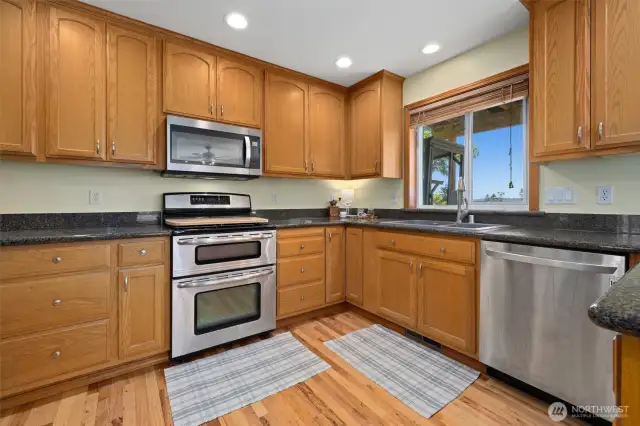 Grand kitchen w/sealed granite counter tops, pristine hardwood floors & stainless steel appliances that are all included.