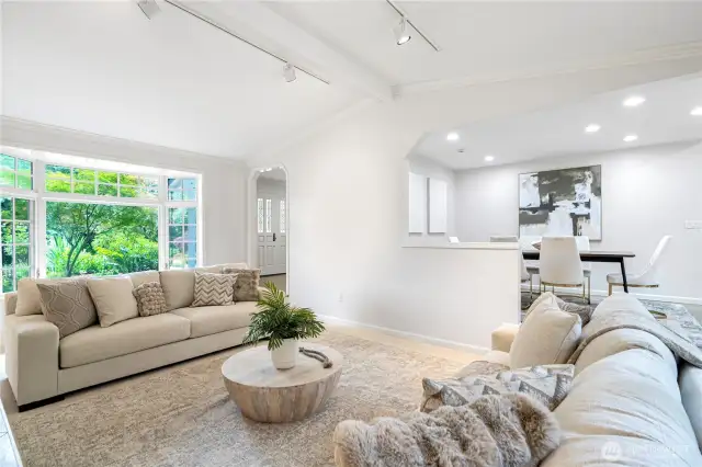 Large picture windows flood the space with nature light and offer scenic views of the lush greenery outside