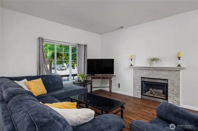 Living area with beautiful laminate floors and cozy gas fireplace.