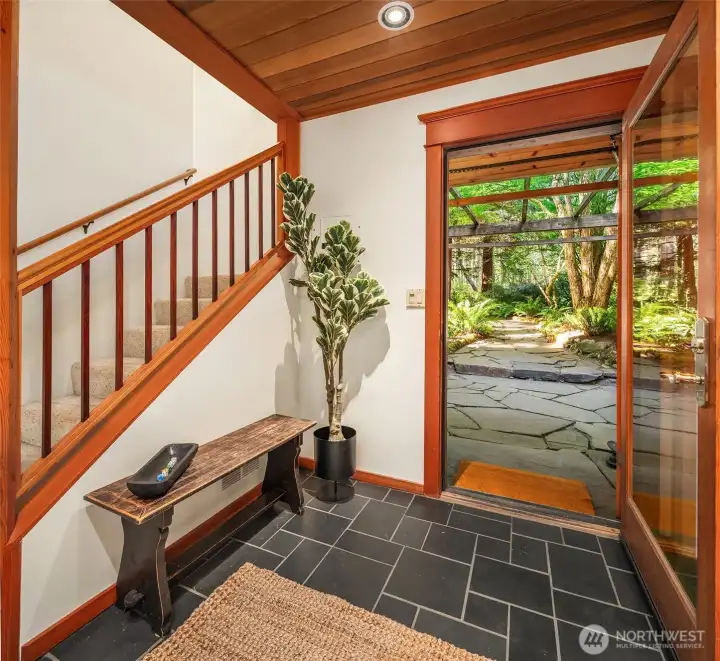 Welcoming entry with slate floor, warm wood ceiling and stairs to the upper levels. It's a happy place to call home.