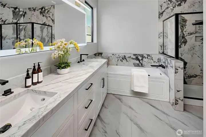 Primary bath with free-standing jetted tub, double sinks, and walk in tiled shower. Virtually staged.