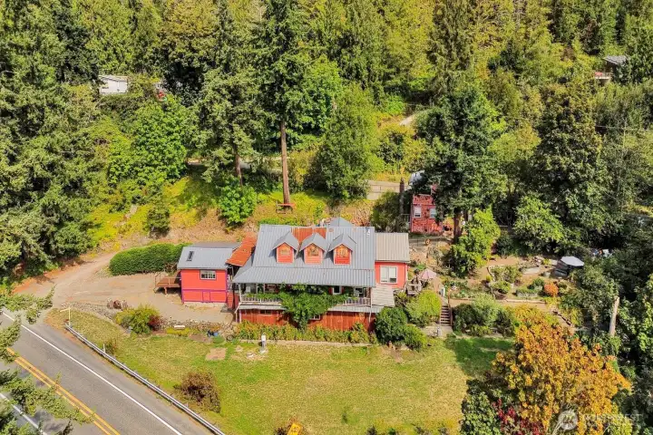 The 1.41 acre property features lush landscaping, a 560 square foot home, and a historic building