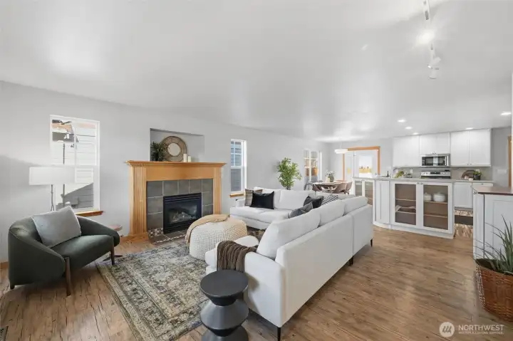 Inside, the open-concept layout flows effortlessly into the cozy living room with a gas fireplace and custom mantle, perfect for quiet evenings or casual entertaining.