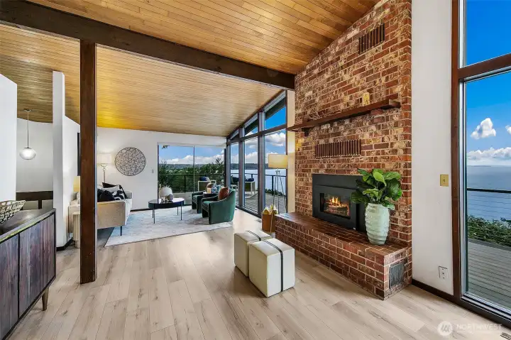 Gas fireplace with original brick work flanks the floor to ceiling windows